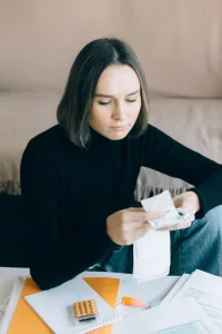 Ung kvinna går igenom räkningar och sin privatekonomi.
